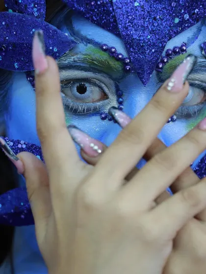 A close-up on the detailed eye work and nail art, showing how every element contributes to the fantasy.