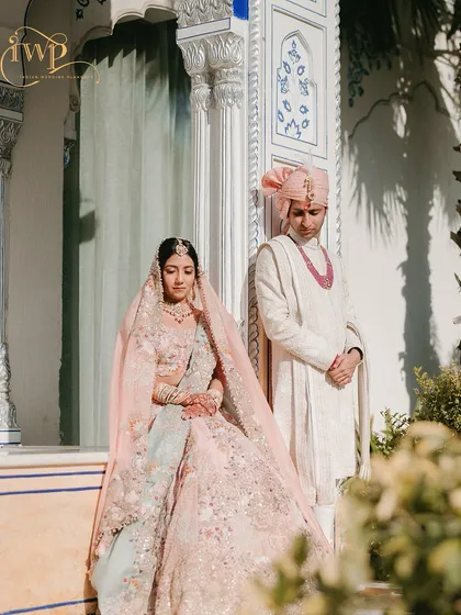 A bride and groom in their stunning pastel wedding attire, perfectly complementing the sunlit palace architecture. I help coordinate every aspect, including wardrobe styling, to ensure a cohesive and elegant visual theme.