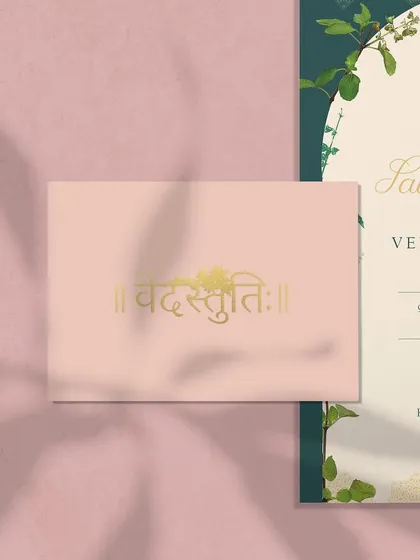 A detail of the custom monogram designed for the Tulsi-themed wedding, shown here in gold foil on a soft pink card. The Devanagari script adds a beautiful, traditional touch.