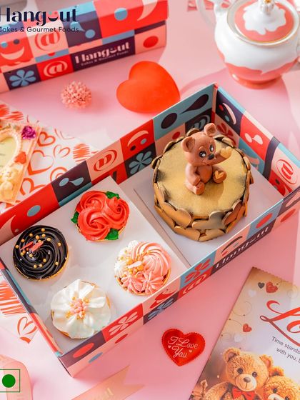 This Valentine's Day gift box features a Dutch truffle bento cake with a cute teddy bear topper, paired with four assorted cupcakes. It's a sweet and indulgent gift for your loved one.