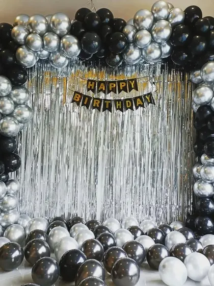 A simple yet elegant black and silver balloon arch against a silver fringe backdrop. This is a versatile setup for any adult celebration.