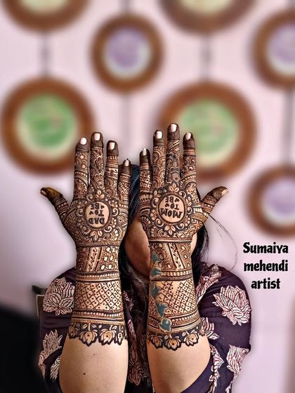 A lovely shot of a 'Dad to be' and 'Mom to be' henna design for a baby shower.