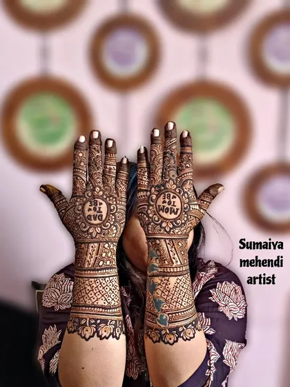 A lovely shot of a 'Dad to be' and 'Mom to be' henna design for a baby shower.