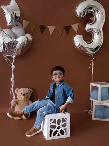 A cool and confident pose from the three-year-old birthday boy. The denim jacket and sunglasses give this shoot a fun, "rockstar" vibe.