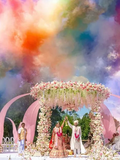 For a modern fairytale wedding, I designed this pastel floral mandap. The look was completed with a dramatic color smoke effect during the varmala, creating a picture perfect moment against the open sky.