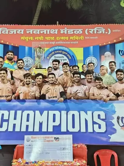Standing behind the 'CHAMPIONS' banner, our team proudly displays the trophy.