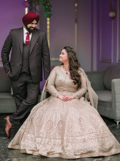 A regal portrait of Ishita and Dipender. Her seated pose in a magnificent gown, with him standing proudly by her side, creates a look of classic elegance and poise.
