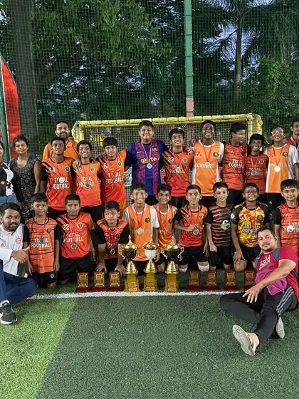 A large group photo of our players, coaches, and parents celebrating multiple wins at the Independence Cup.