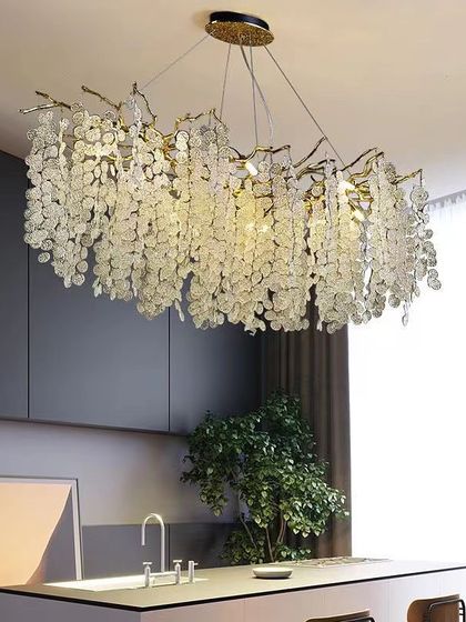 A rectangular chandelier with hanging crystal leaves, ideal for placement over a kitchen island or long dining table.