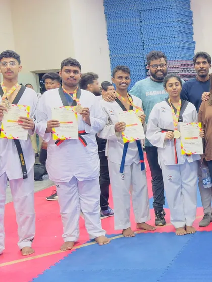 Our athletes and coaches celebrating together after a successful tournament. The strong bond within our Taekwondo family is a key part of our success.