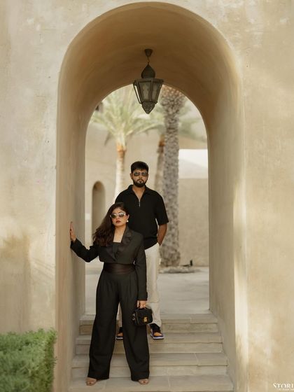 A powerful, symmetrical portrait of the couple framed by a stone archway in Al Seef, Dubai.