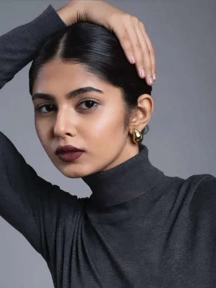 A bold and modern look featuring a deep, matte burgundy lip. The skin is kept clean and the hair is styled in a sleek low bun to keep all the focus on the powerful lip color.