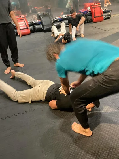 A student practices ground-and-pound on a training dummy. This drill is about developing the aggression and technique needed to end a fight if it goes to the ground.