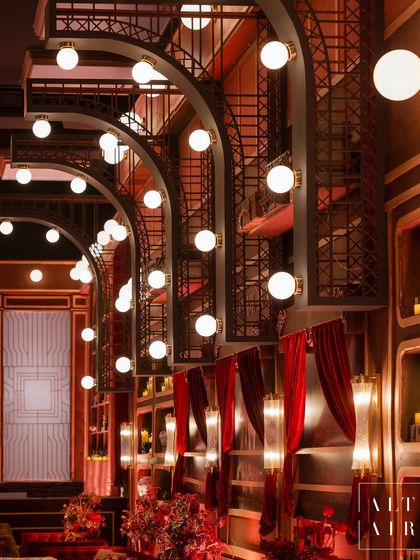The interior of the ballroom was structured to mimic the inside of a luxury train, with curved archways and booth-style seating. The warm, dramatic lighting and rich red velvet curtains enhanced the romantic, vintage atmosphere of European rail travel.