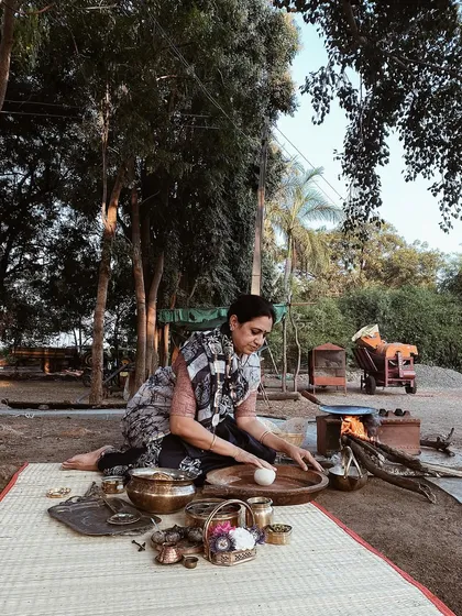 A behind-the-scenes moment of styling on location. This shot shows the hands-on work of preparing food in a natural, outdoor setting, staying true to the brand's organic roots.
