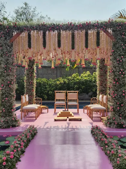 The mandap appears to float on the water, with a pink walkway leading to it. This design is perfect for clients looking for a unique and memorable ceremony setup.