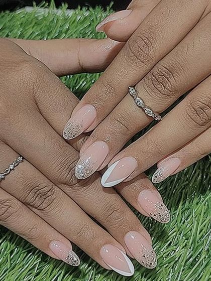A beautiful set combining a V-French tip with sparkling silver glitter tips on almond-shaped nails.