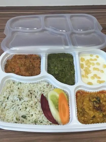 We deliver wholesome and delicious packed meal thalis, perfect for office lunches or events. This pure vegetarian meal includes jeera rice, dal, a vegetable preparation, raita, and salad, all neatly packed and ready to enjoy.