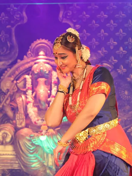 A shy, endearing expression. This subtle gesture can convey a range of emotions, from modesty to affection, showcasing the nuanced art of facial expression in dance.