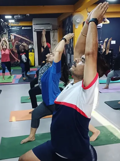 Another view of the Veerbhadrasana (Warrior Pose) in a group setting. This pose not only builds physical strength but also cultivates mental determination and focus.