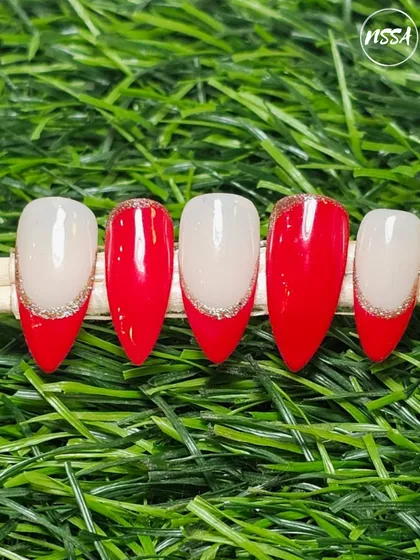 A modern take on the classic French manicure, created by a student. This design features a bold red tip with a delicate silver glitter smile line for a touch of sparkle.