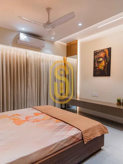A floating console table in this bedroom serves as a minimalist TV unit, with a serene Buddha artwork above it. The backlighting behind the curtains adds a soft, ambient glow to the space.