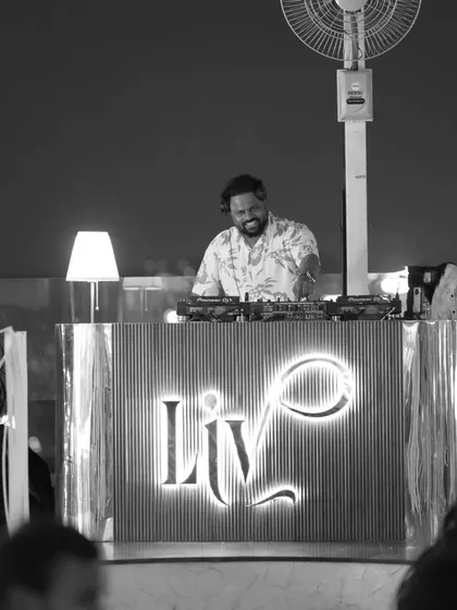 A black and white photo from a sundowner event at LIV. The focus is on me at the console, smiling as I mix, capturing the pure joy I find in playing music.