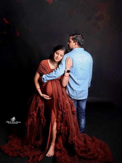 A tender moment captured from a unique angle. The mom-to-be leans on her partner's shoulder, creating a sense of trust and intimacy.