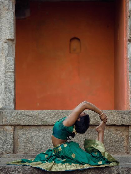 A seated one-legged king pigeon pose, showing the combination of hip opening and spinal flexibility.