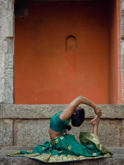 A seated one-legged king pigeon pose, showing the combination of hip opening and spinal flexibility.
