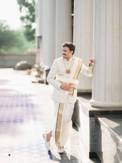 A classic portrait of the groom in his traditional South Indian wedding attire.