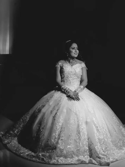 A stunning black and white portrait of the bride in her ballgown. The framing and lighting create a dramatic and elegant image.