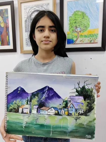 A teen student works on a scenic watercolor landscape, learning to create depth and atmosphere with washes of color.