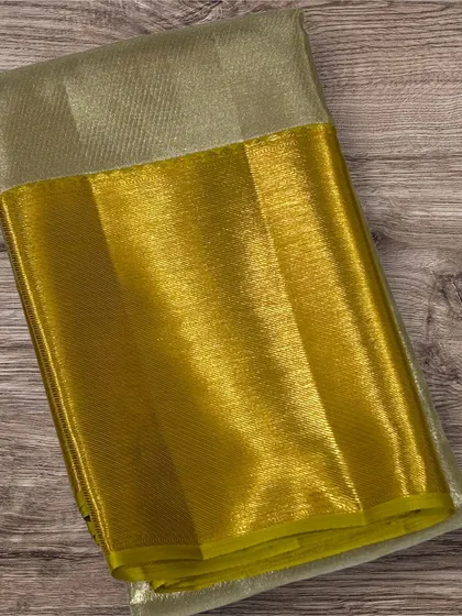 A pure Kanchi silk saree with a silver tissue body and a bright yellow-gold border.