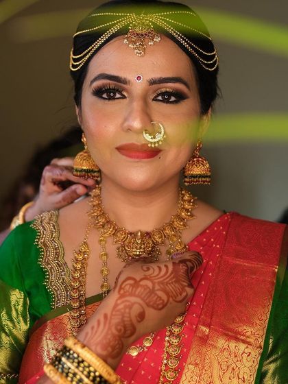 Getting ready for the big moment. This shot captures the complete look with the intricate matha patti and heavy gold jewellery, essential for a traditional bride.