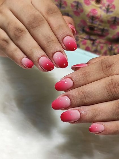 Another view of the soft red ombre nails, showing the smooth transition of color and the glossy finish.