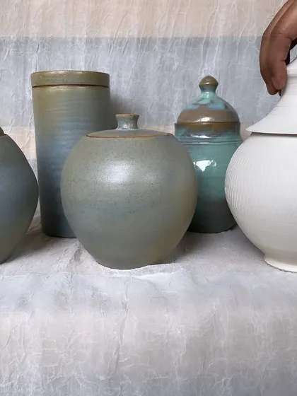 A collection of lidded jars from an intermediary course, showcasing different shapes, lid styles, and glaze finishes. Lidded forms are a great challenge for developing pottery skills.