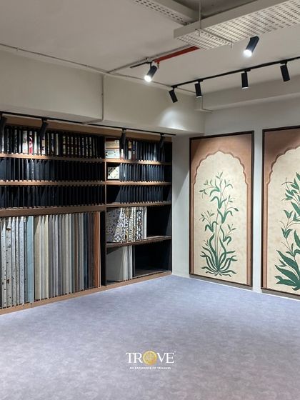 In my Mysore Road experience center, you can browse through an extensive library of tile samples organized for easy viewing. This setup, shown here next to two large botanical murals, allows for effortless comparison of textures, colors, and patterns.