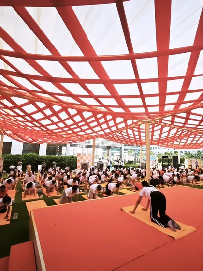 Leading a large group through a coordinated yoga flow. These events are a great way to foster a sense of community and shared purpose within a company.