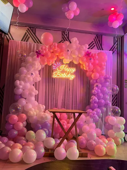 The final setup of the pastel balloon arch, with balloons scattered on the floor to create a dreamy, cloud-like effect.