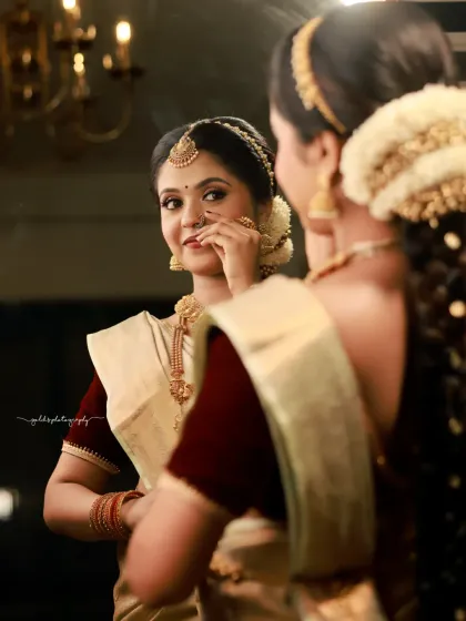 A mirror shot that creates a sense of intimacy and reflection. The bride's expression is serene as she gets ready, and the warm lighting adds to the classic ambiance.