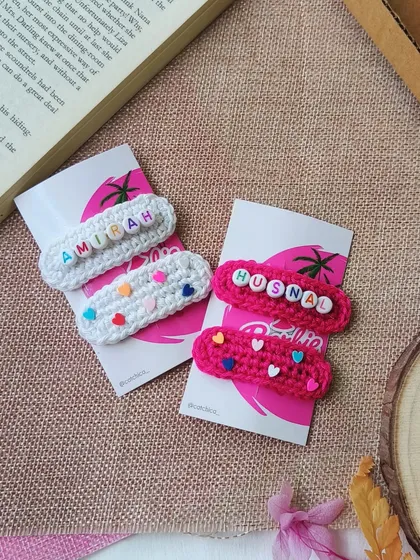 A closer look at the 'Amirah' and 'Husnal' name clips, showing the different styles you can choose from. One with just the name, and the other with adorable little heart beads.