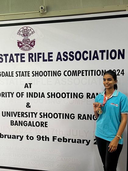 Bhashitha proudly posing with her gold medal won in the Air Rifle Women's event at the 1st Nagaraja Jagdale Shooting Competition.