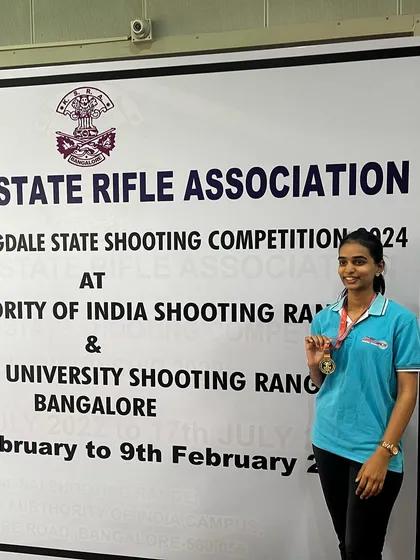 Bhashitha proudly posing with her gold medal won in the Air Rifle Women's event at the 1st Nagaraja Jagdale Shooting Competition.