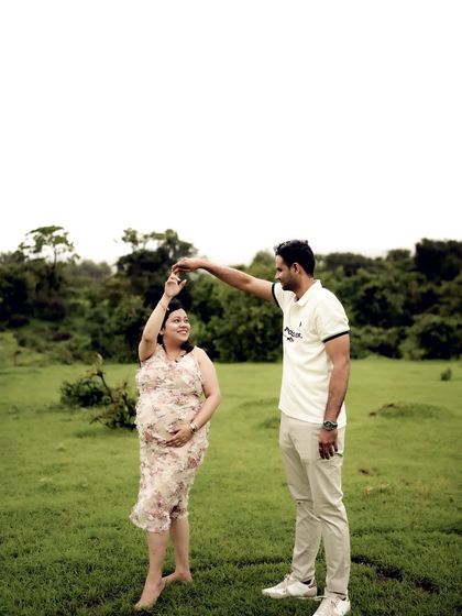A playful moment of the couple dancing in a field. His hand raised to twirl her captures a moment of fun and romance.