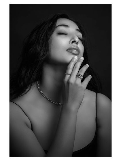 A contemplative black and white portrait. The model's expression is soft and thoughtful, creating a beautiful and emotive image.