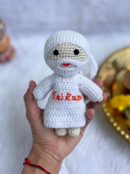 A serene doll of Sai Baba, dressed in all white with "Sai Ram" embroidered on his robe. These dolls bring a sense of peace and make a thoughtful gift for devotees.