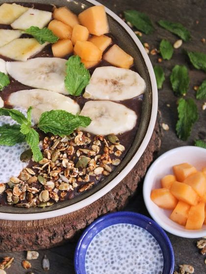 Our smoothie bowl is a unique blend of fruits, topped with our homemade granola and fresh mint. It's crafted to refresh and revitalize your day.