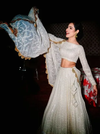 The joy of wearing a beautiful outfit. This photo captures the movement of the white Chikankari lehenga, showing off the flow of the skirt and the delicate dupatta.