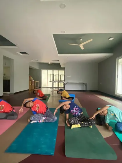 I believe in starting them young, and my kids' yoga classes are pure joy. Here you can see a group of children learning side stretches, building flexibility and body awareness through playful movement, not rigid instruction.